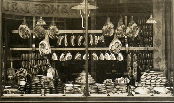 This shop window of the butcher Johann Friedrich Fischer from Orlach in South Shields shows piles and strings of his varied assortment of sausages and pork pies.