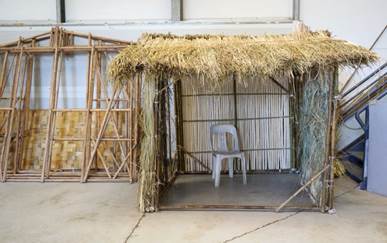Fig. 23 : Une réalisation de Richard Patterson, avec les panneaux de calumets tressés utilisés pour la réalisation de Latlyé Kamayann en arrière-plan, 2023.